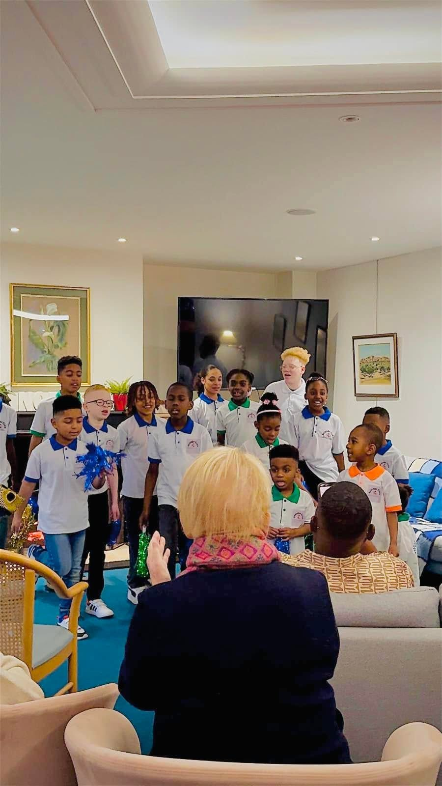 Chœur d'enfants en polos Akwaba Eden interprétant des chants devant les personnes âgées