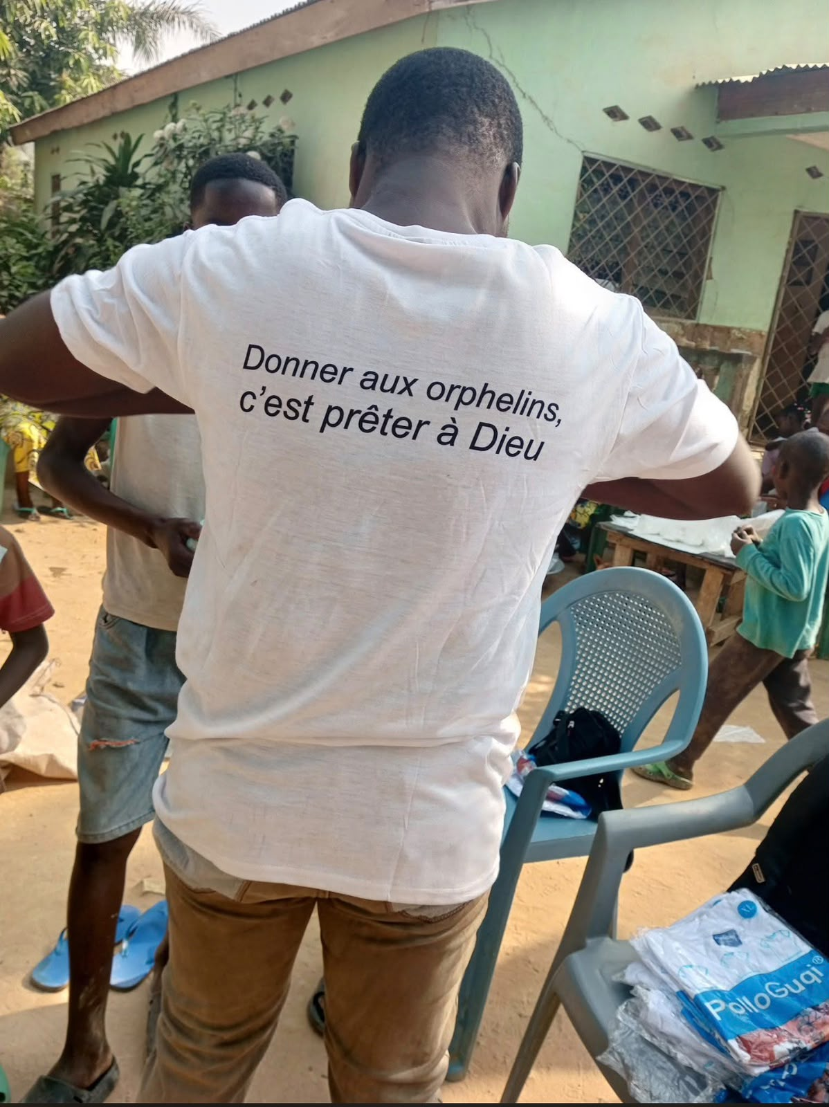 Bénévole d'Akwaba Eden portant le t-shirt « Donner aux orphelins, c'est prêter à Dieu » lors de l'action à Bangui
