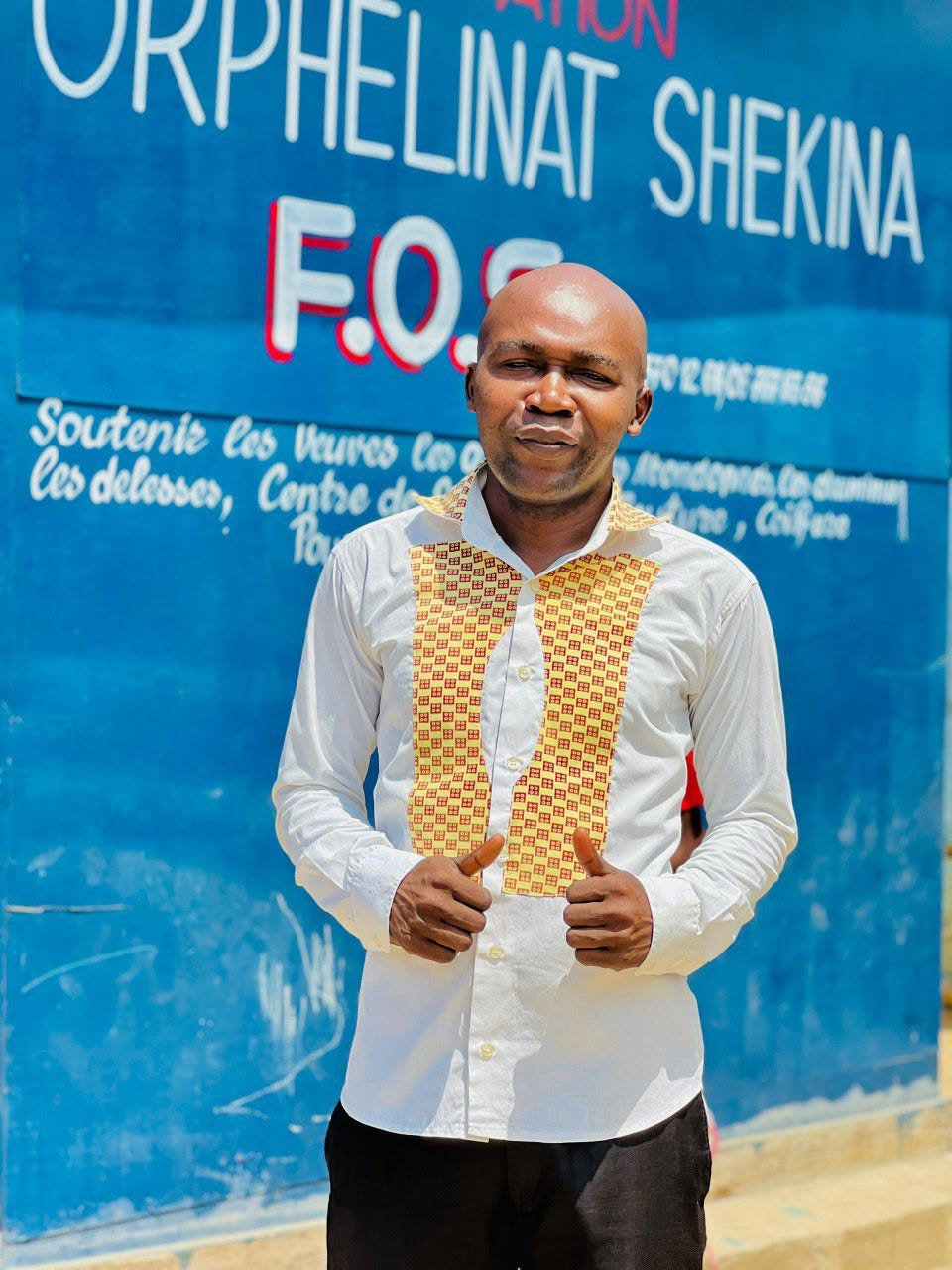 Portrait du responsable de la Fondation Orphelinat Shekina devant la façade peinte du centre